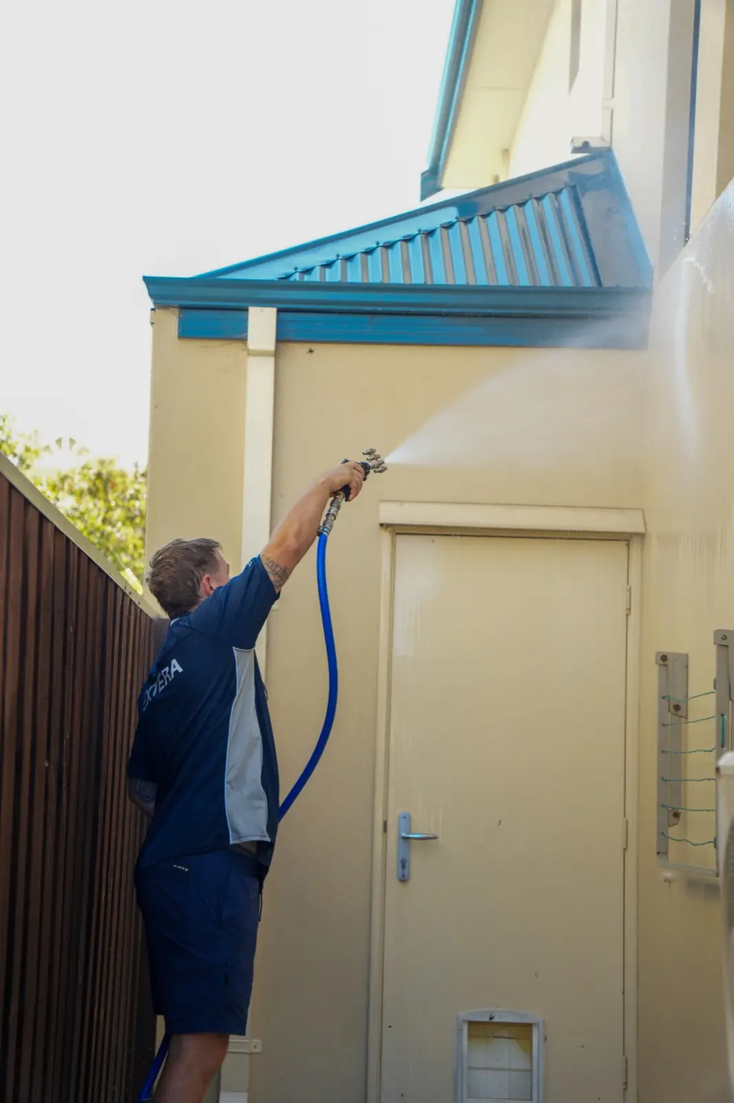 Extera operator soft washing a house exterior wall in Perth