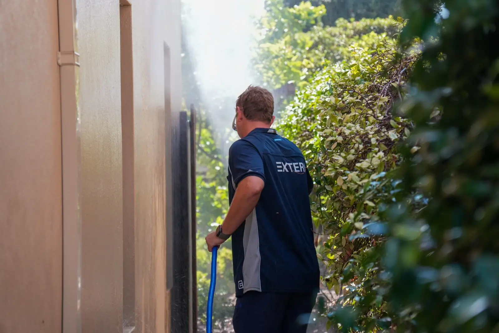 Extera operator soft washing a rendered wall in Perth